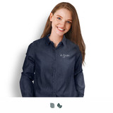A woman wears a stylish dark denim button-up shirt featuring a logo on the chest.