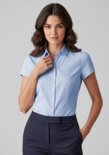 A light blue women's short sleeve button-up shirt with a fitted design, paired with navy trousers.