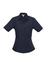 A navy short sleeve button-up shirt with two chest pockets and a fitted design. It features a logo on the label. A navy short sleeve button-up shirt with two chest pockets and a fitted design. It features a logo on the label.