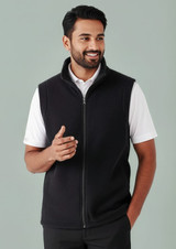 A black micro fleece vest with a zip, worn by a smiling man in a white shirt. The vest features a stand-up collar and has a logo.