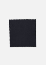 A square piece of fabric in a solid dark colour with a textured finish and a zigzag edge. A square piece of fabric in a solid dark colour with a textured finish and a zigzag edge.