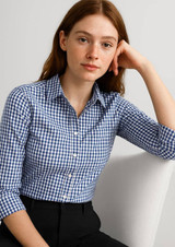A woman models a blue and white gingham button-up shirt with 3/4 sleeves. The shirt has a collar and buttons.