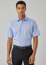 A short-sleeve button-up shirt in light blue, featuring a collar and a logo. Styled with black trousers and a belt.