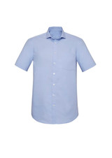 A light blue short sleeve button-up shirt with a pocket and a standard collar. It features a simple design and has a logo.