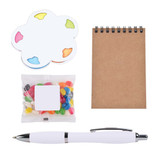 A white pen, a small notepad, colourful sticky notes, and a bag of jelly beans in assorted colours. A white pen, a small notepad, colourful sticky notes, and a bag of jelly beans in assorted colours.