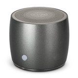 A grey Swiss Peak Bass Speaker with a textured surface and a circular grill on top, featuring a branding logo. A grey Swiss Peak Bass Speaker with a textured surface and a circular grill on top, featuring a branding logo.