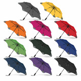A collection of BLUNT Metro Umbrellas in various colours, including grey, orange, yellow, pink, green, black, and purple.