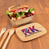 A metallic lunch box with a wooden lid, filled with a sandwich, salad, and fruit. Includes wooden utensils. A metallic lunch box with a wooden lid, filled with a sandwich, salad, and fruit. Includes wooden utensils.