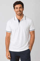 A white polo shirt with navy contrast detailing, featuring a collar and short sleeves. It has a logo on the chest.