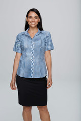 A short-sleeve button-up shirt in blue and white gingham pattern, modelled by a woman standing with a smile.