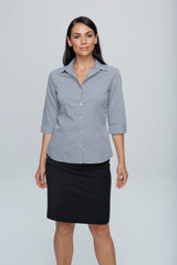 A woman poses in a grey button-up shirt with 3/4 sleeves, paired with a black skirt. The shirt features a logo. A woman poses in a grey button-up shirt with 3/4 sleeves, paired with a black skirt. The shirt features a logo.