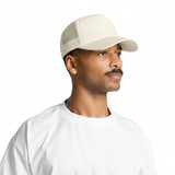 A foam trucker cap in cream, featuring mesh sides and a curved brim, worn by a man with a moustache.