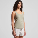 A soft green singlet worn by a model, styled with light-coloured shorts. The top features a simple design and includes a logo.