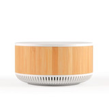 A bamboo and white wireless speaker with a sleek, modern design and a circular shape. It features a branding logo.
