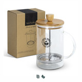 A glass coffee plunger with a bamboo lid sits next to its kraft box packaging. A glass coffee plunger with a bamboo lid sits next to its kraft box packaging.
