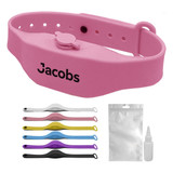 A pink wristband hand sanitiser dispenser with additional multi-coloured bands and a small bottle for refilling.