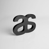 A black acrylic plaque shaped like stylised letters, featuring a sleek, modern design. A black acrylic plaque shaped like stylised letters, featuring a sleek, modern design.