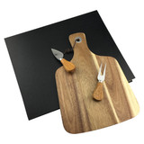 A wooden cheeseboard with two cheese knives, set on a black background. The board features a handle and a hole for hanging.