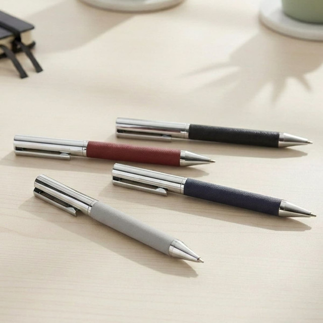 A set of four Geneva metal pens in grey, red, black, and navy with a sleek design and branding.