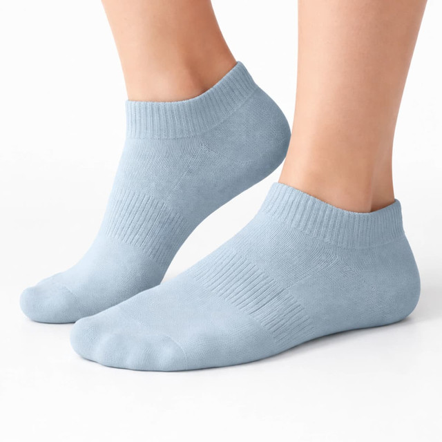 Ankle grip socks in light blue, featuring a ribbed design and low-cut style, displayed on a pair of feet.
