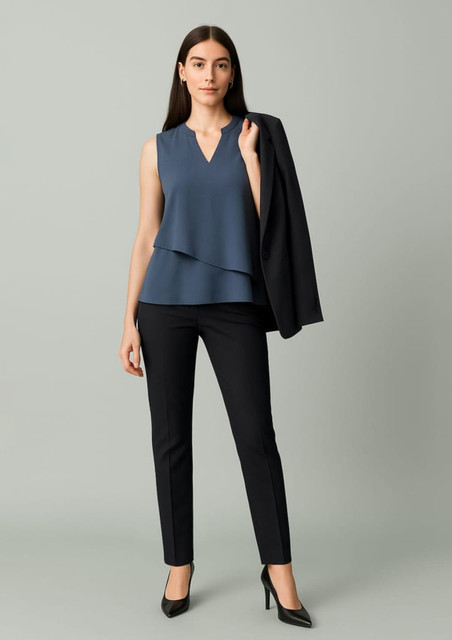 A woman in a blue top and black mid-waist slim leg pants holds a black blazer, set against a neutral background.