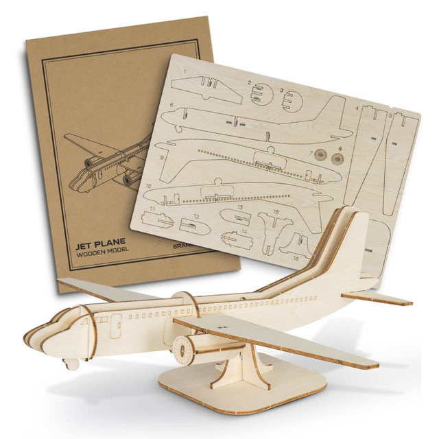 A wooden model of a jet plane in natural colour, with assembly instructions displayed behind it.