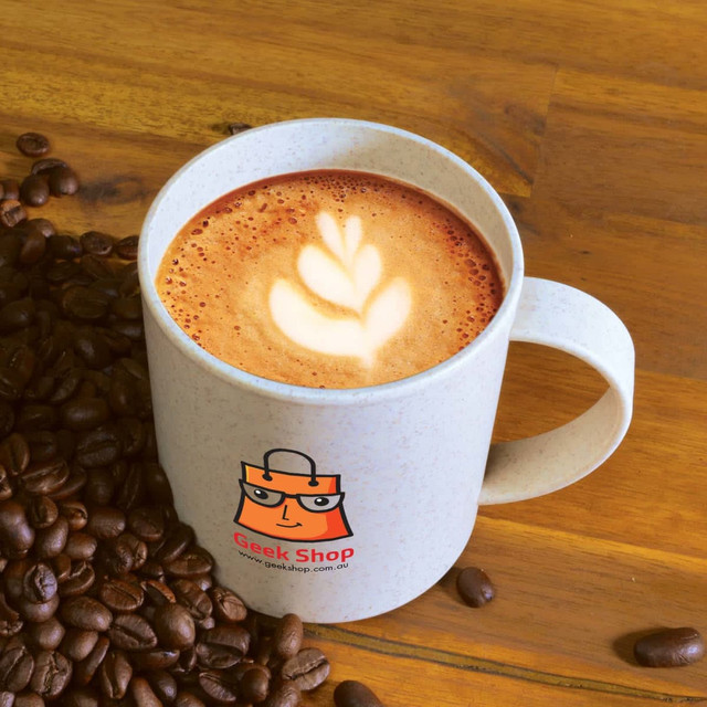 A reusable mug in light grey with a logo, filled with coffee and resting among coffee beans. A reusable mug in light grey with a logo, filled with coffee and resting among coffee beans.