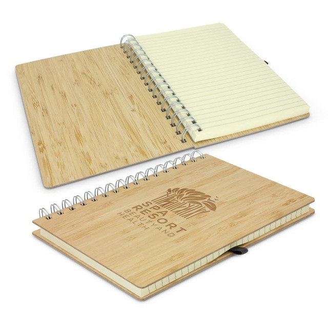 A bamboo notebook with a spiral binding, featuring a natural wood finish and lined pages. It includes a branded logo. A bamboo notebook with a spiral binding, featuring a natural wood finish and lined pages. It includes a branded logo.