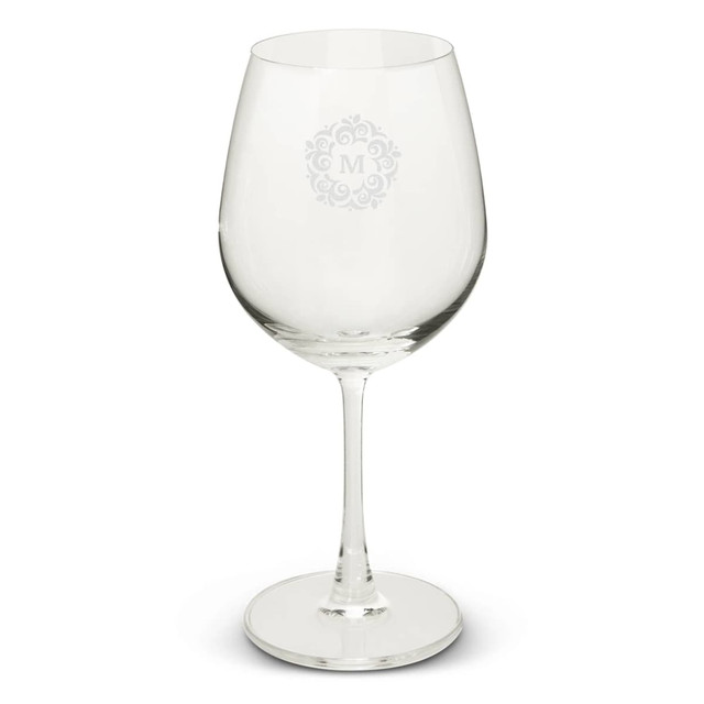 A clear wine glass with a large bowl and a slender stem, featuring a decorative logo design. A clear wine glass with a large bowl and a slender stem, featuring a decorative logo design.