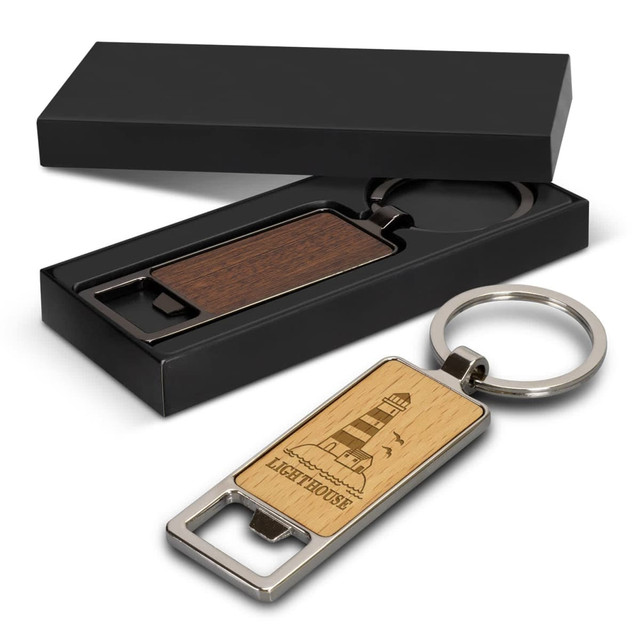 A drink bottle opener key ring in brown wood and silver metal, presented in a black box. A drink bottle opener key ring in brown wood and silver metal, presented in a black box.