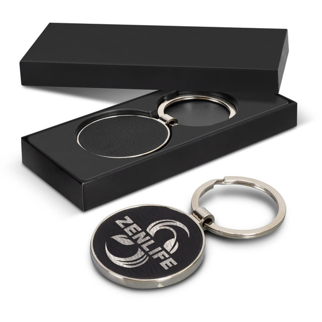 A round silver key ring with a leather centre, presented in a sleek black gift box. A round silver key ring with a leather centre, presented in a sleek black gift box.