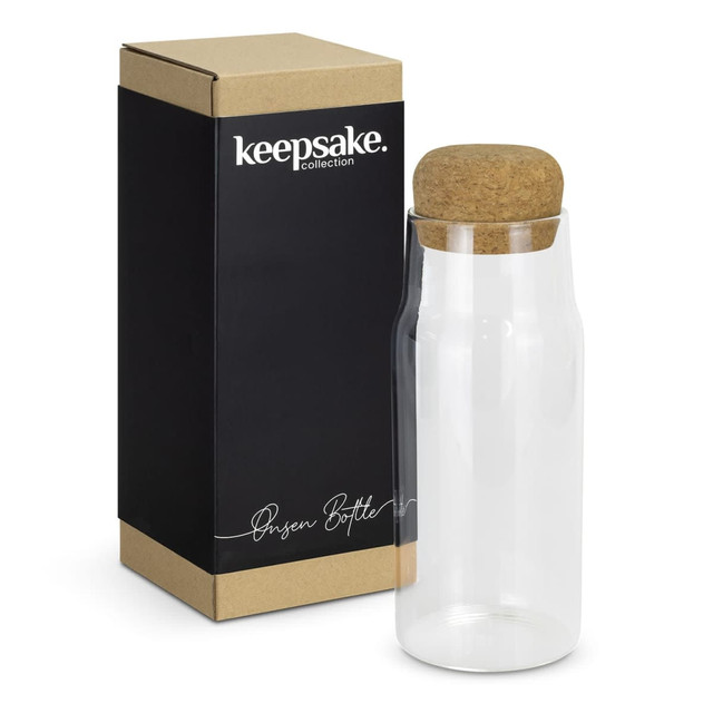 A drink bottle with a clear glass body and a cork lid, presented in a box featuring a logo. A drink bottle with a clear glass body and a cork lid, presented in a box featuring a logo.