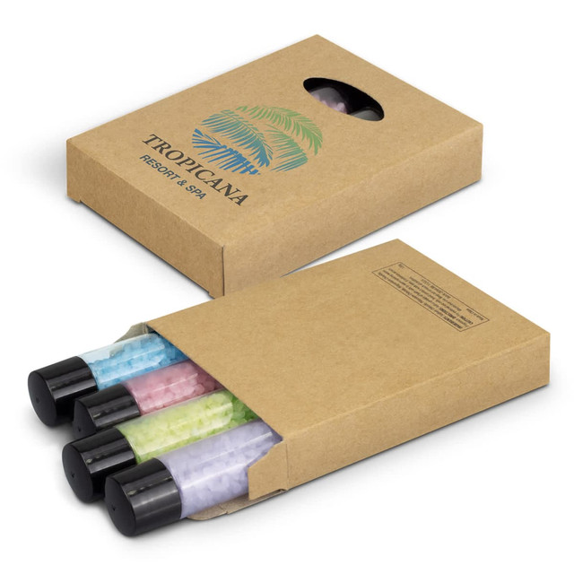 A box containing three bottles of spa bath salts in pastel colours: pink, green, and purple. The box features a logo. A box containing three bottles of spa bath salts in pastel colours: pink, green, and purple. The box features a logo.
