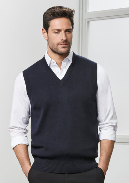 A men's woolmix knit vest in navy, featuring a V-neck and worn over a white shirt, with a logo on the side. A men's woolmix knit vest in navy, featuring a V-neck and worn over a white shirt, with a logo on the side.