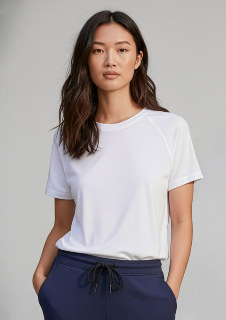 A white short sleeve tee with a relaxed fit, featuring a logo, paired with navy trousers.