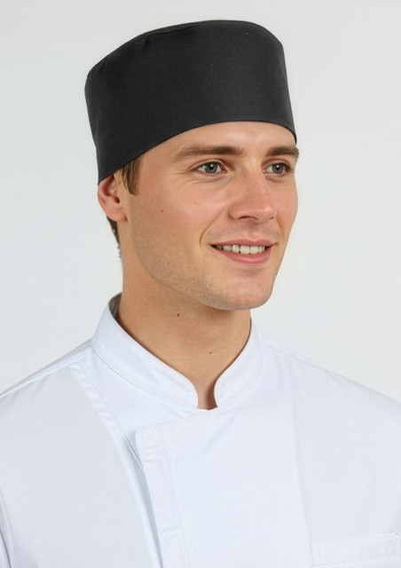 A black mesh flat top hat worn by a smiling male model in a white chef's coat. The hat features a logo.