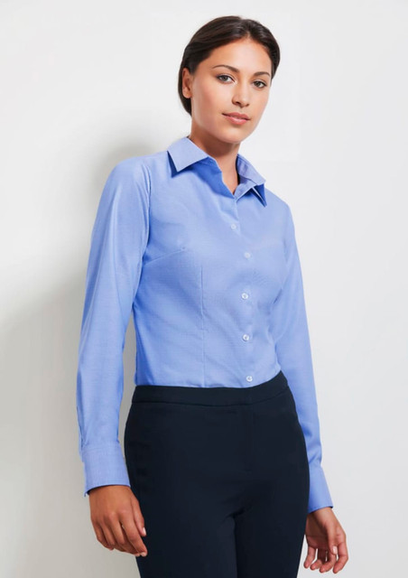 A blue women's long sleeve button-up shirt with a collar, featuring a fitted design and a logo.