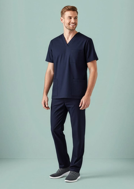 A model wearing navy blue scrub pants with matching scrub top, featuring a pocket. The outfit has a sleek, professional look.