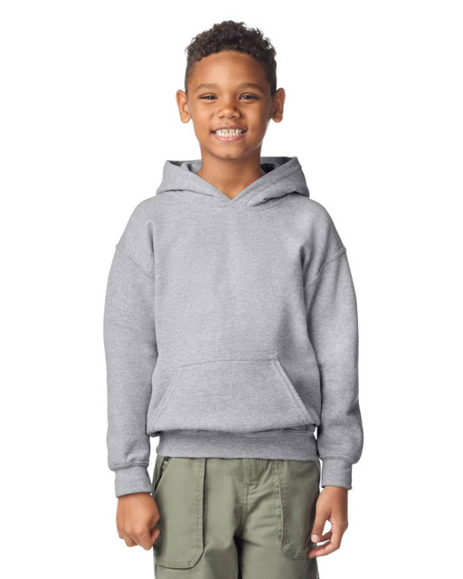 A youth hooded sweatshirt in grey, featuring a front pocket and a drawstring hood. The model is smiling and wearing casual pants.