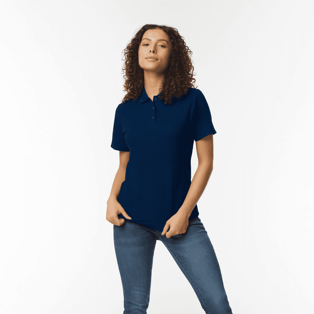 A model wearing a navy blue ladies' double pique polo shirt, featuring a logo, paired with denim jeans. A model wearing a navy blue ladies' double pique polo shirt, featuring a logo, paired with denim jeans.