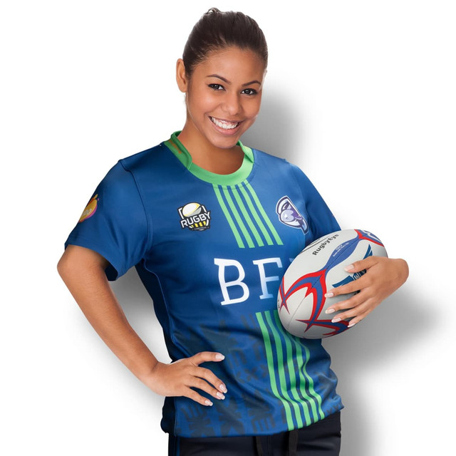 A woman in a blue and green custom rugby t-shirt holds a rugby ball, featuring a logo on the shirt. A woman in a blue and green custom rugby t-shirt holds a rugby ball, featuring a logo on the shirt.