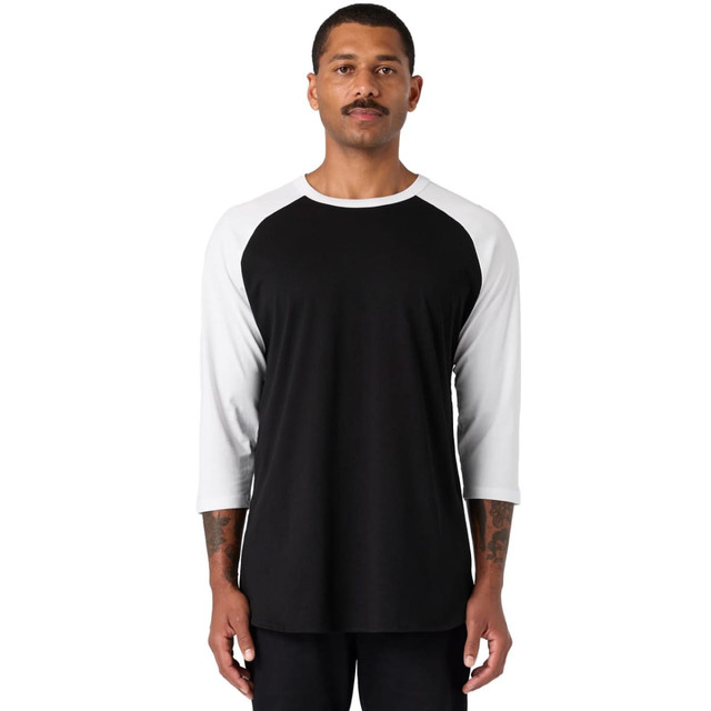 A black and white raglan tee shirt, featuring three-quarter sleeves and a casual fit, worn by a model.