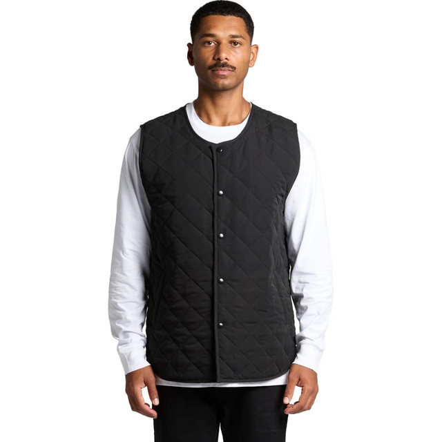 A man wearing a black quilted vest over a white long-sleeve shirt, featuring a button-down front and a simple design.