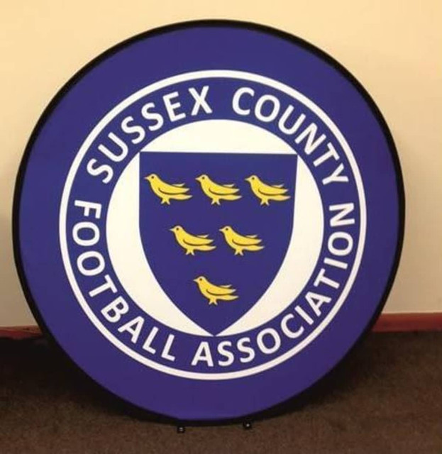 A round pop-up banner with a purple background and a central shield design featuring six yellow birds. It includes a logo.