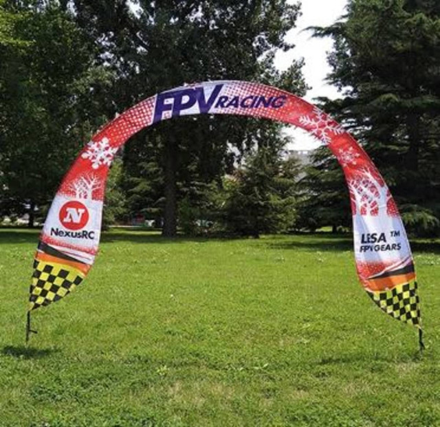 A promotional arch banner featuring red and black colours, with a checkered border and a logo on each side.