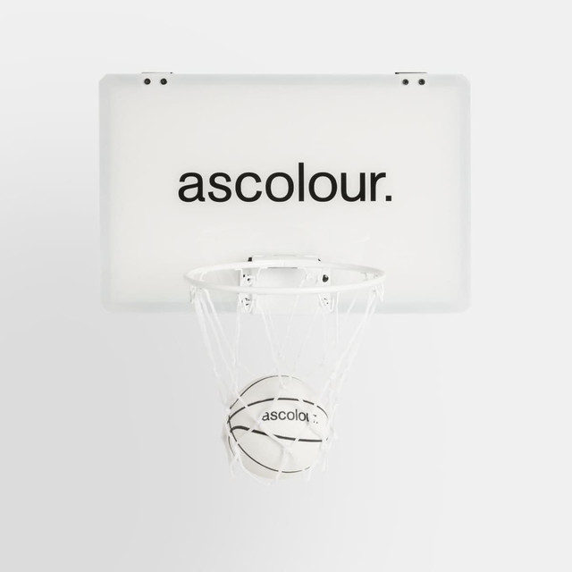 A mini basketball hoop set featuring a white backboard and a small basketball, both with branding.
