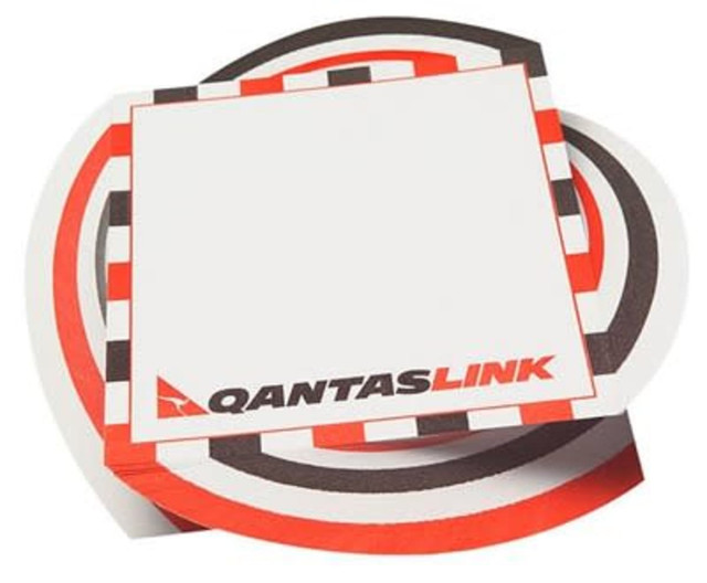 A stack of small note pads featuring a circular design in red, black, and white, with a logo. A stack of small note pads featuring a circular design in red, black, and white, with a logo.