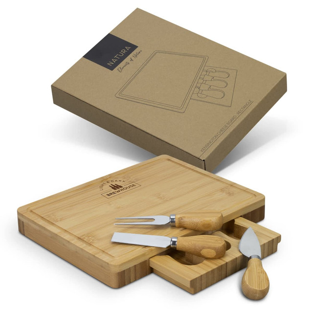 A rectangular bamboo cheese board with three stainless steel knives, displayed in a brown box. A rectangular bamboo cheese board with three stainless steel knives, displayed in a brown box.