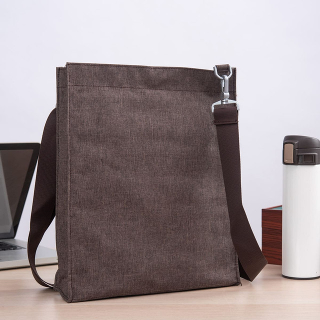 A brown nylon library bag with a shoulder strap, placed next to a laptop and a drink bottle on a table.