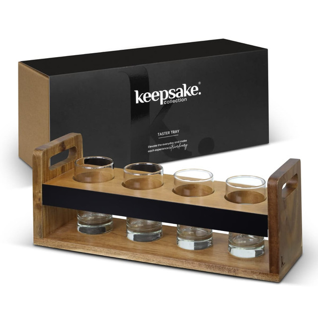 A wooden taster tray with a sleek black band holds four clear glass containers, packaged in a black box. A wooden taster tray with a sleek black band holds four clear glass containers, packaged in a black box.